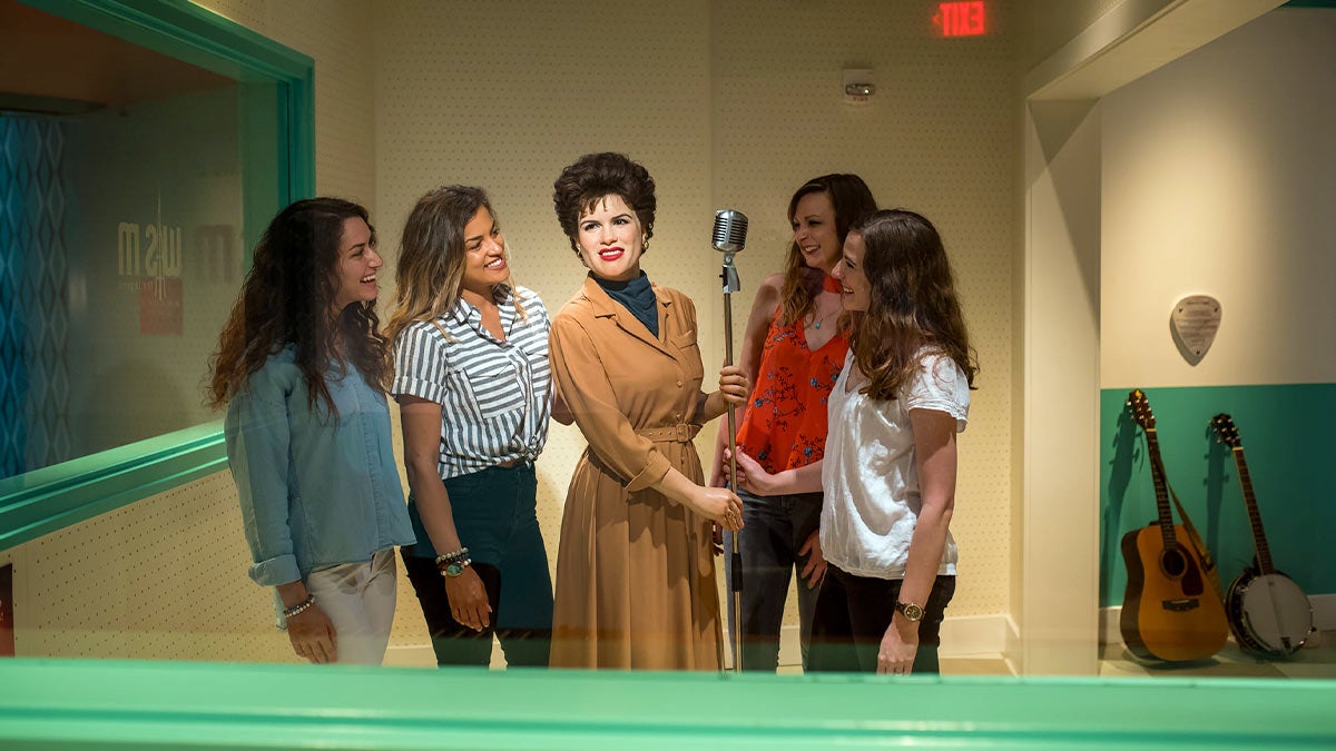 group of girls are smiling while singing a song
